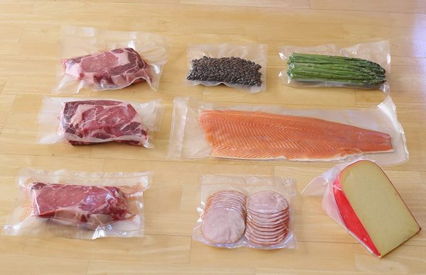 Vacuum seal bags with meat, fish and veggies in them